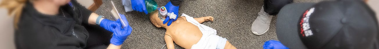 STARS_NewsArticle Pediatric manikin laying on the ground being administered oxygen