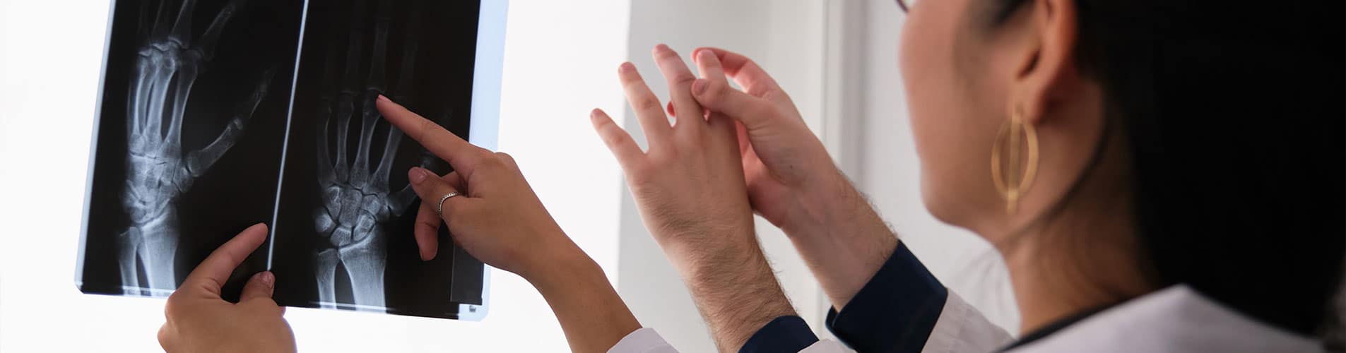 A rheumatologist examines hand joints on an x-ray