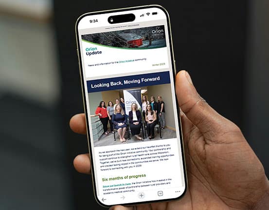 Hand holding a phone with a preview of the second Orion Update enewsletter on the screen