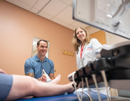 SpecialtyTrainingAtRuralSites A rheumatologist examines hand joints on an x-ray